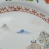 Een reeks van vier Chinees porseleinen bordjes met meerkleurige landschapsdecors. Tijdperk Qianlong. Enkele randschilfers en twee met haarscheur.