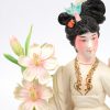 “Vrouw met bloemen”. Een fijn gesculpteerd en gepolychromeerd ivoren beeldje op houten sokkel. China, medio XXe eeuw.