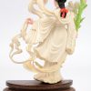 “Vrouw met bloemen”. Een fijn gesculpteerd en gepolychromeerd ivoren beeldje op houten sokkel. China, medio XXe eeuw.