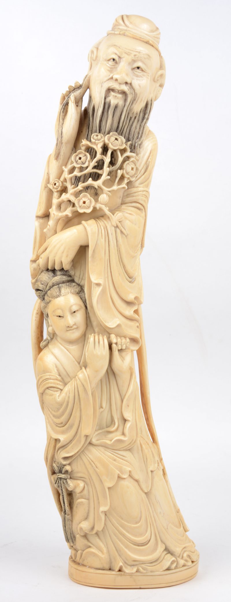 “Oude wijze met vrouw”. Een gesculpteerd ivoren beeld. Onderaan gesigneerd. China, begin XXe eeuw. Instrument manco