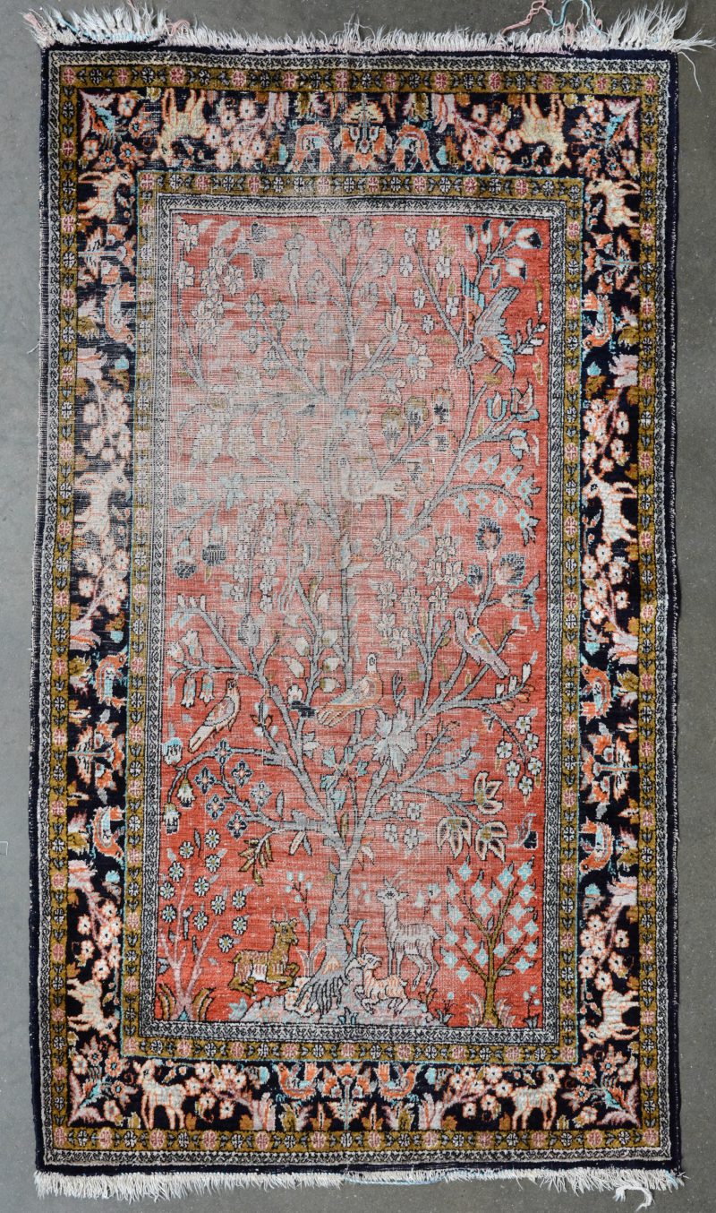 Een handgeknoopt Perzisch kleedje van zijde met een levensboom in het decor. Slijtage.