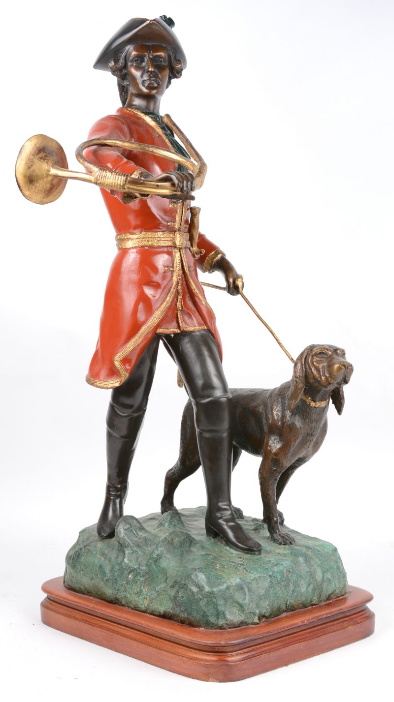 “Engelse jager met hond en hoorn”. Een bronzen groep met deels meerkleurig partina op houten voetstuk.