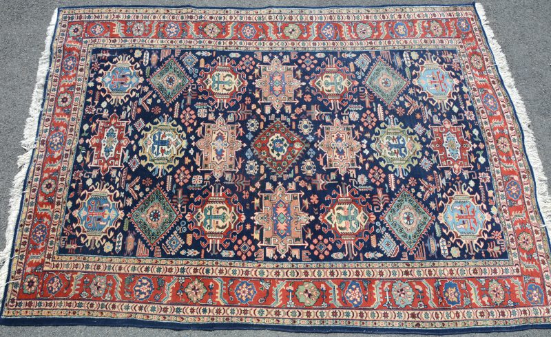 Een handgeknoopt Perzisch wollen tapijt met geometrishe motieven.