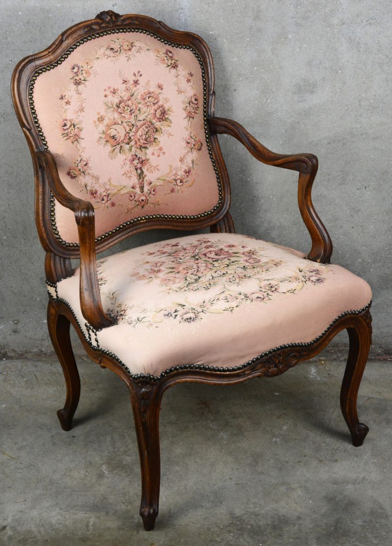 Een fauteuil à la reine in Lodewijk XV-stijl, bekleed met naaldwerk.
