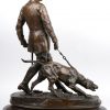 “Jager met jachthond”. Een bronzen groep op zwart marmeren sokkel. Gesigneerd.