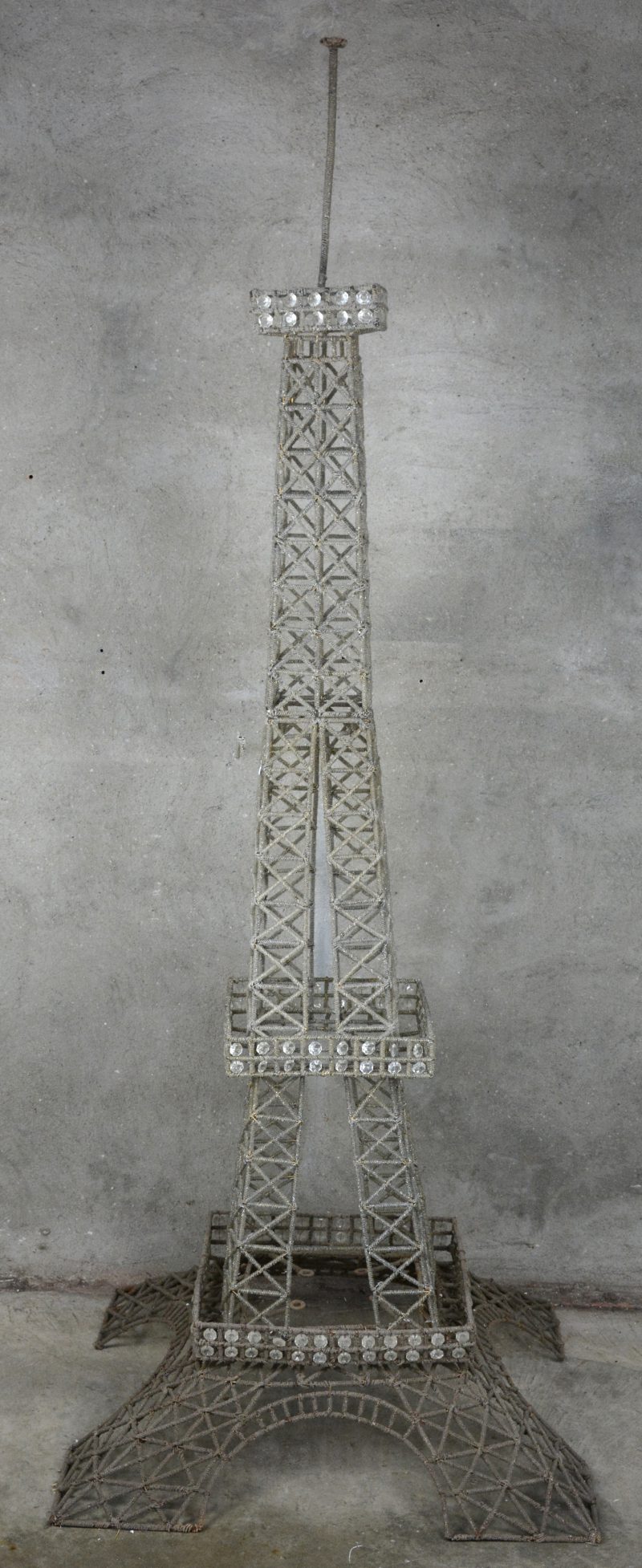Een model van de Eiffeltoren, bestaande uit drie delen van metaaldraad en versierd met doorschijnende kraaltjes van kunststof.
