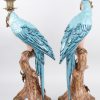 Een paar kandelaars van brons en meerkleurig porselein in de vorm van papegaaien.