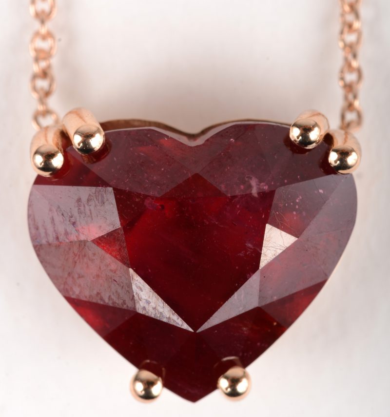 Een 18 K roze gouden ketting met hanger bezet met een hartvormige behandelde robijn van +- 8,20 ct.