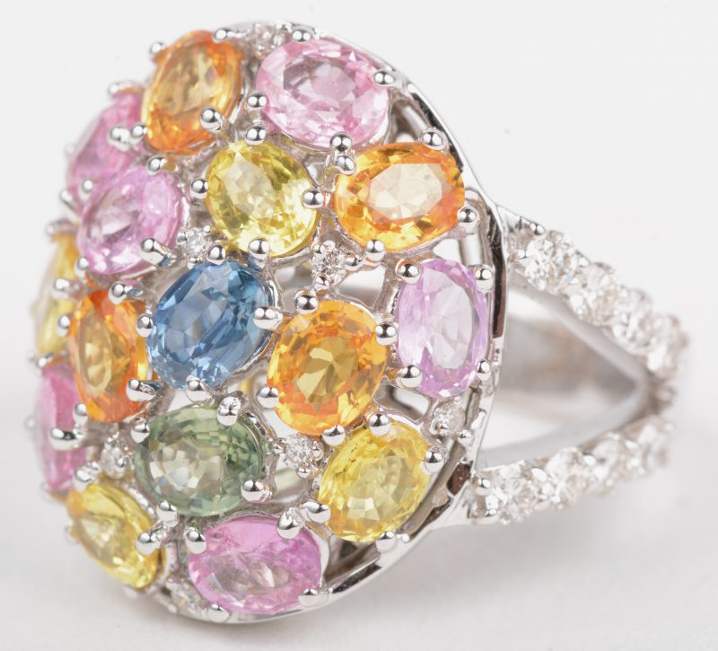 Een 18 K witgouden ring bezet met een verschillende kleuren saffier met een gezamenlijk gewicht van +- 3,20 ct. en briljanten met een gezamenlijk gewicht van +- 0,50 ct.