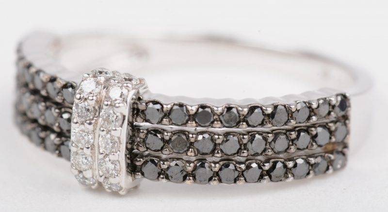 Een 18 K witgouden ring bezet met briljanten met een gezamenlijk gewicht van +- 0,28 ct. en zwarte diamanten met een gezamenlijk gewicht van +- 1,08 ct.