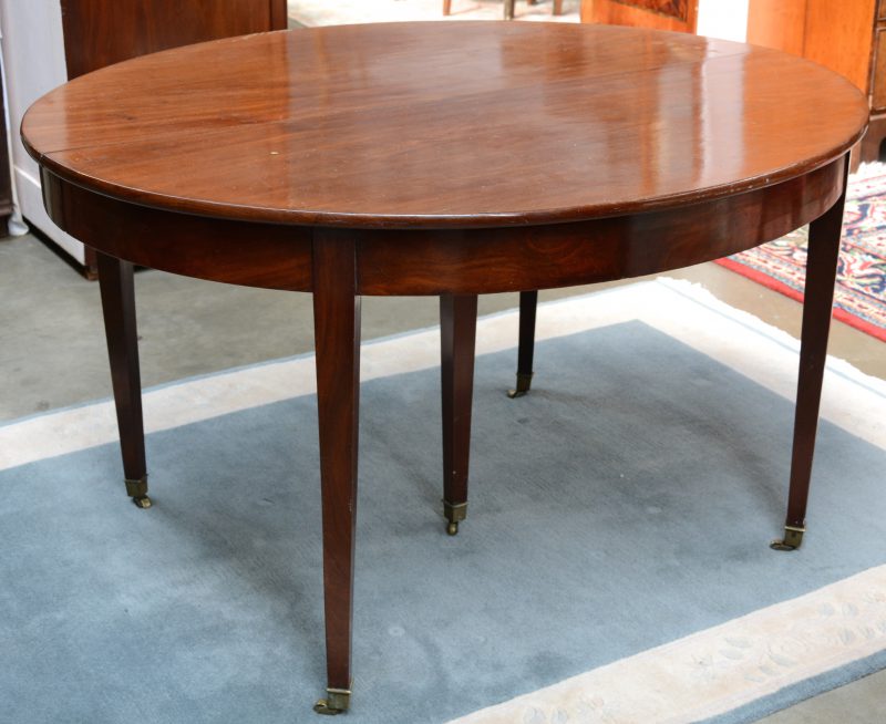 Een ovale tafel van mahoniehoutfineer met vier tapse poten. XIXe eeuw.