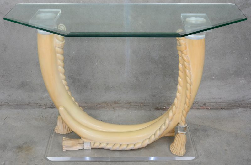 Moderne consoletafel met plexiglazen voet en tablet, gedragen door twee slagtanden van imitatie-ivoor.