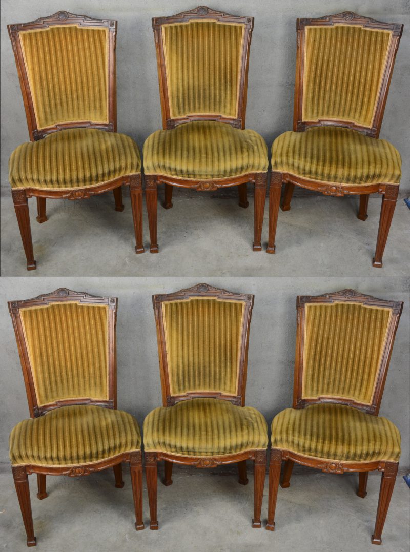 Een serie van zes notenhouten stoelen in Hollandse Lodewijk XVI-stijl. Ruggen versierd met een guirlande en met een centraal vrouwenhoofd in medaillon. Gestreept fluwelen bekleding. Begin XIXde eeuw.