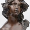 Een bronzen meisjesbuste in art nouveaustijl naar een werk van moreau.