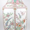 Een zeshoekige balustervaas van Chinees porselein met een decor van vogels in bloeiende heesters en handvatten, in de vorm van vruchten. Onderaan gemerkt.