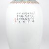 Een vaas van Chinees porselein met een decor van pauwen en pioenen. Met houten sokkel.