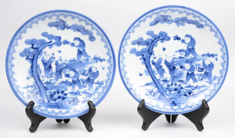 Een paar borden van Japans porselein met een blauw op wit decor van zotjes. Onderaan gemerkt.