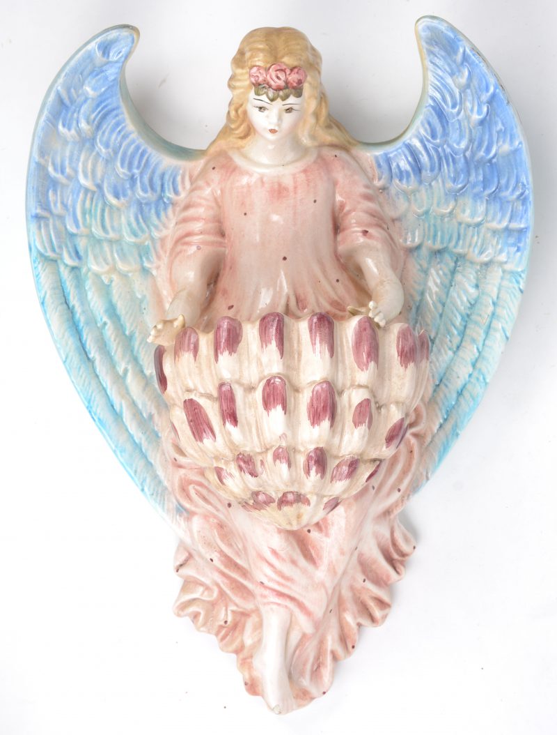 Een meerkleurig aardewerken wandvaas in de vorm van een engel. Italiaans werk. Schilfer aan het voetje.