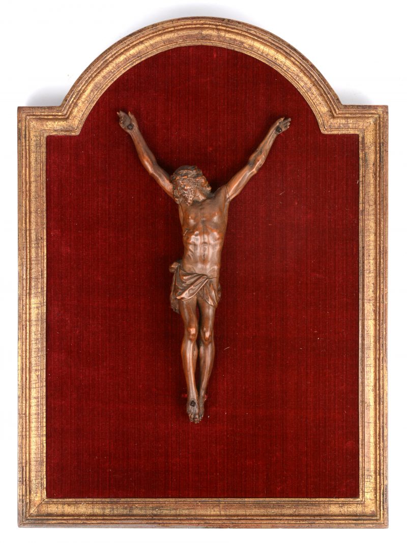Een barokke Christus in een vergulde lijst met rood fluweel.