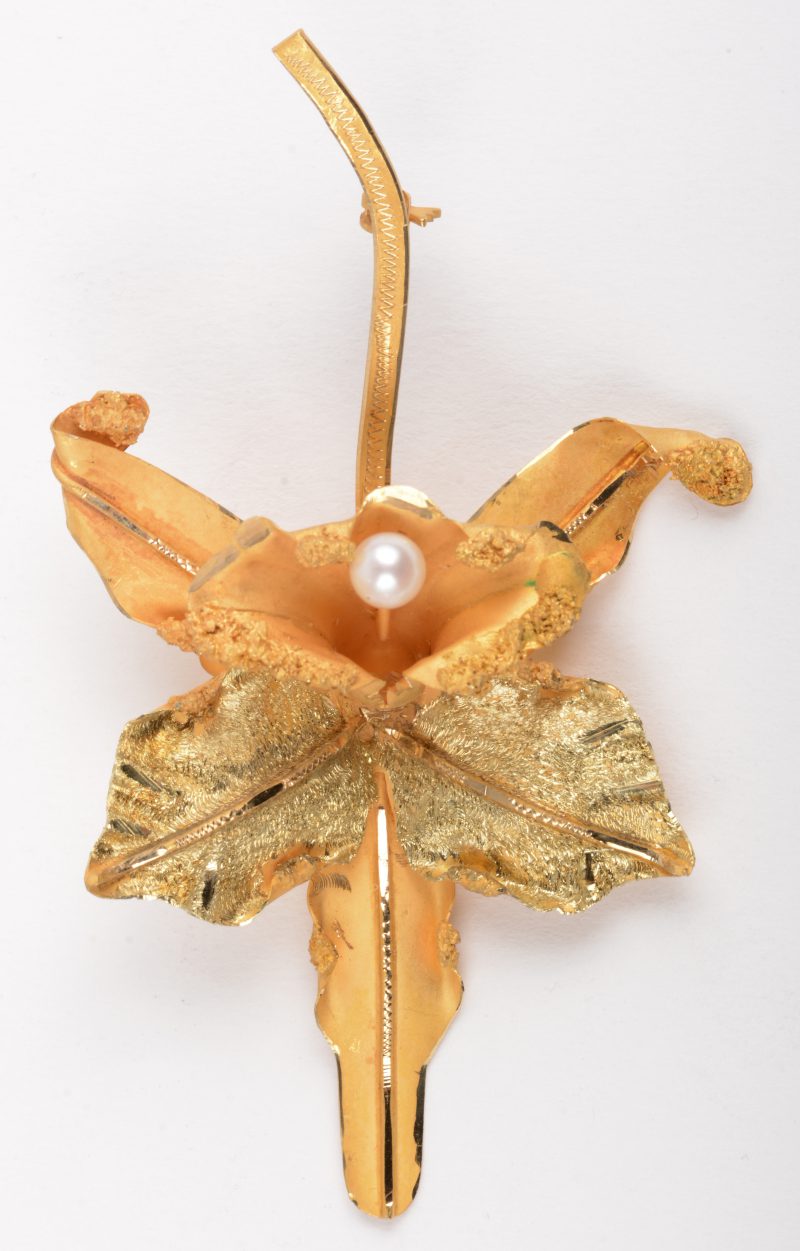 Een broche van geel goud 18 K in de vorm van een bloeiende tak, versierd met een parel.