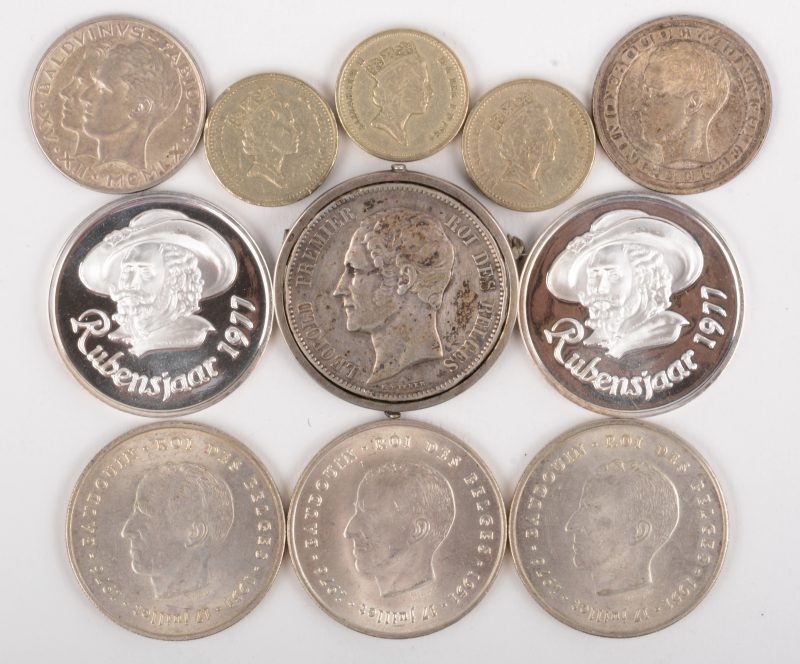 Een lot zilveren munten en medailles met : 5 BEF, Leopold I, 1865 (in speld), 3 x 250 BEF (1976). 2 x 50 BEF. 2 x Rubensjaar 1977. We voegen er drie stukken van one pound aan toe.