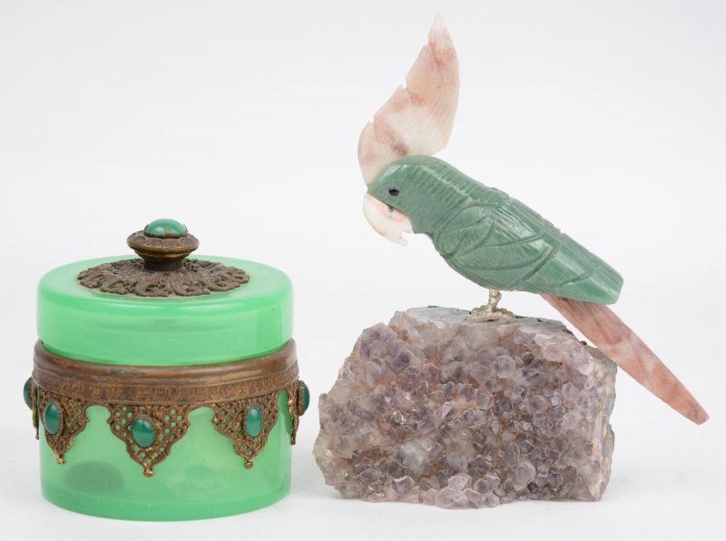 Een groen glazen juwelendoosje en een kaketoe van mineralen.