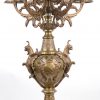 Een rijkelijk uitgewerkt bronzen klokstel in barokke stijl. De pendule  met gevleugelde leeuwen, barokke dolfijnen en twee putti bij een fontein. De kandelaars met vijf lichtpunten.