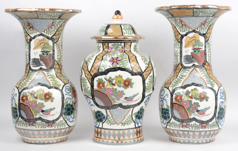 Een driedelig aardewerken kaststel, bestaande uit twee kraagvazen en een dekselvaas met Chinese decors. Onderaan gemerkt.