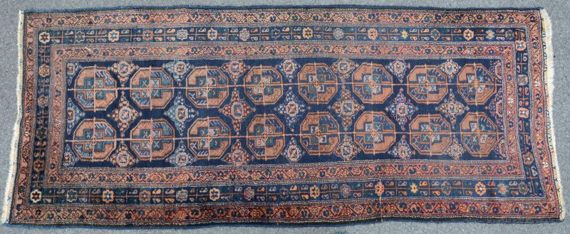 Een antiek handgeknoopt Oosters wollen tapijt.