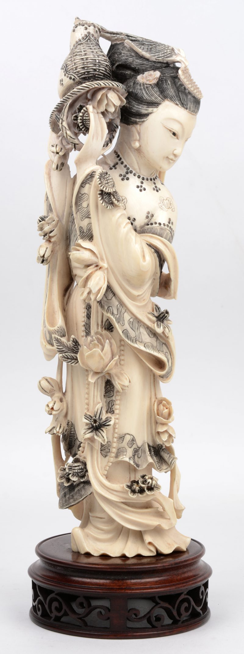 “Vrouw met mand en bloemen” Een beeld van gesculpteerd Chinees ivoor op houten sokkel. XXe eeuw.