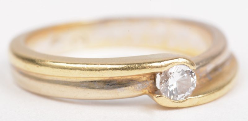 Een 18 K wit en geelgouden ring bezet met een solitair van +- 0,20 ct.