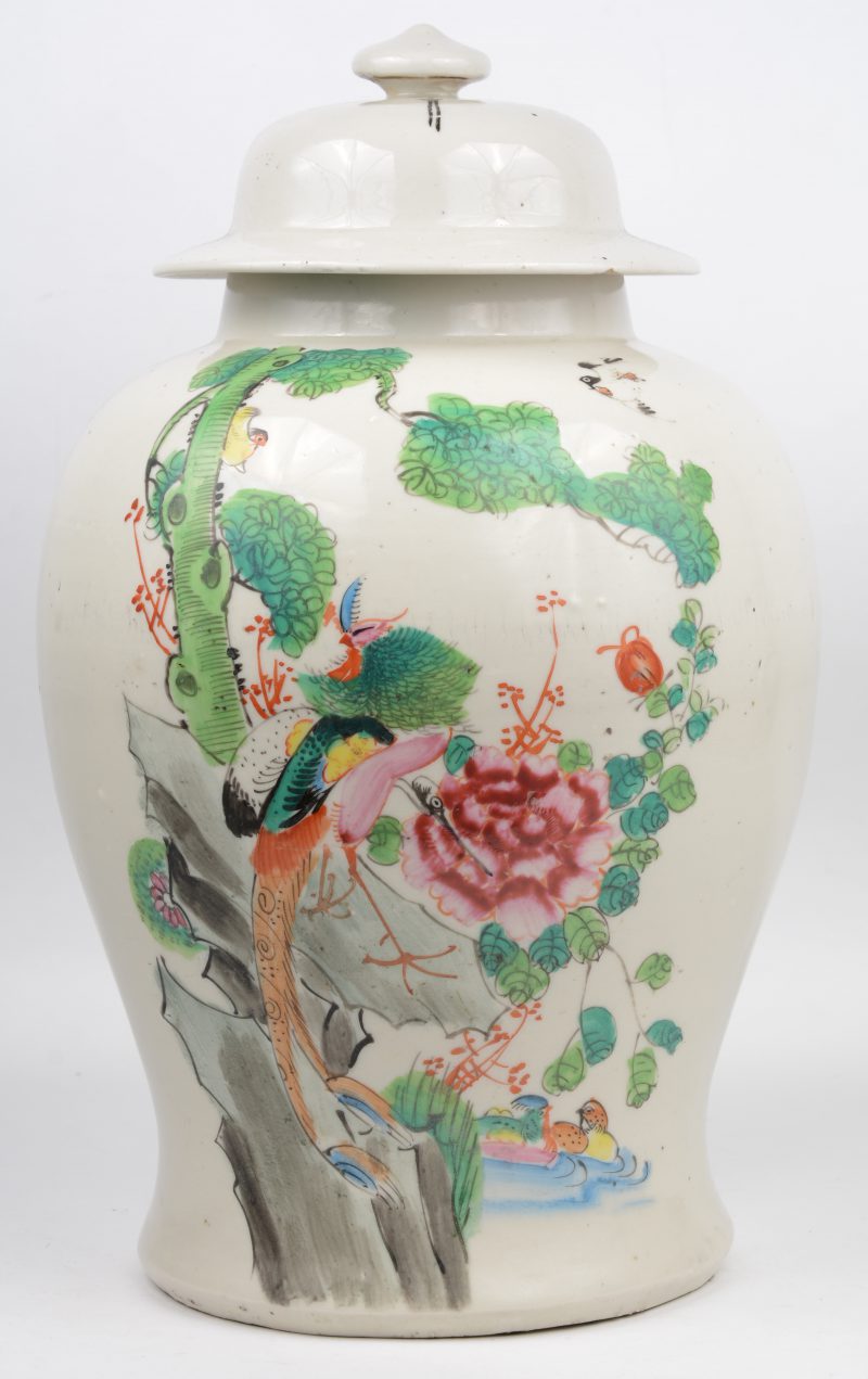 Een dekselvaas van Chinees porselein met een merkleurig decor van vogels bij een vijver.