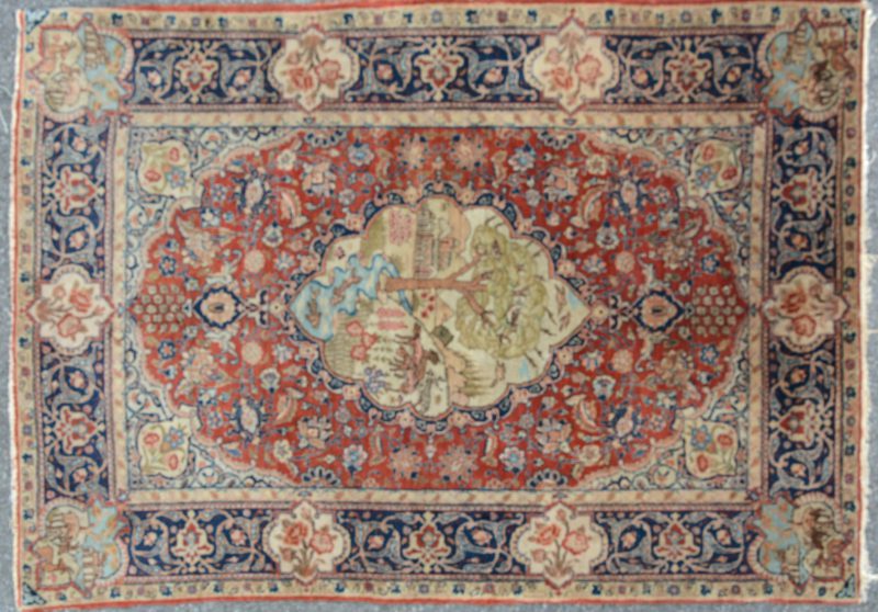 Een antiek handgeknoopt Perzisch wollen tapijtje met decors van landschappen met dieren en bloemen in cartouches.