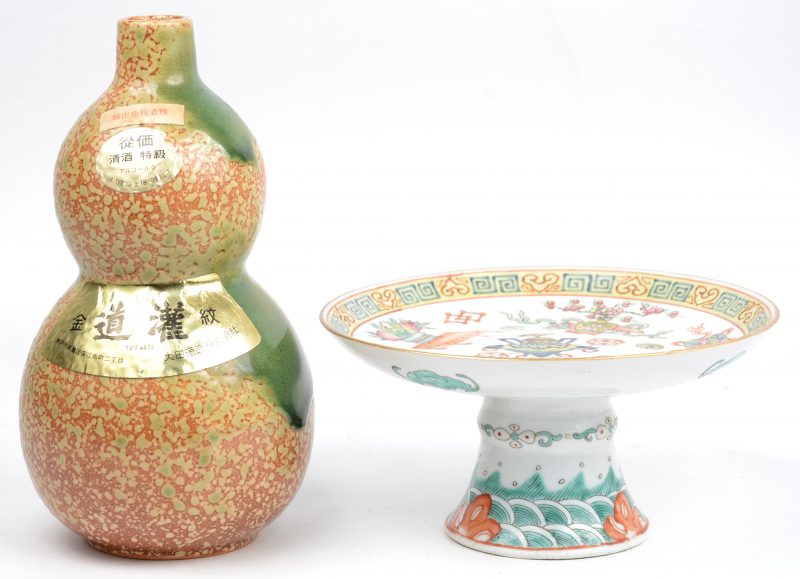 Een kalebasvaasje van Chinees aardewerk en een kleine tazza van Chinees porselein met een meerkleurig decor van kostbaarheden. Het eerste gemerkt.