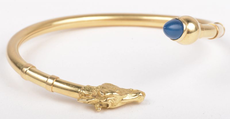 Een 18 K geelgouden armband met een paardenhoofd en een licht blauwe steen.