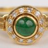 Een 18 K geelgouden ring bezet met briljanten met een gezamenlijk gewicht van +- 0,15 ct. en een smaragd cabochon van +- 0,25 ct.