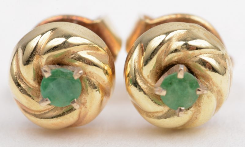 Een paar 18 K geelgouden oorbellen bezet met twee kleine smaragdjes.