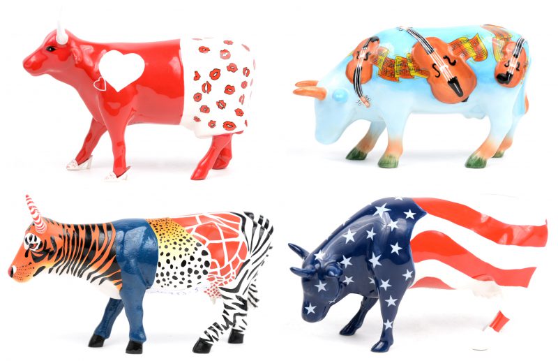 “Moo Zoo”; “The Moozart moment”; “Americaow the beautiful” & “Moocho amor”. Vier koeien uit de reeks ‘Cow Parade’ naar het gelijknamige kunstproject. Drie porseleinen en één van kunststof.