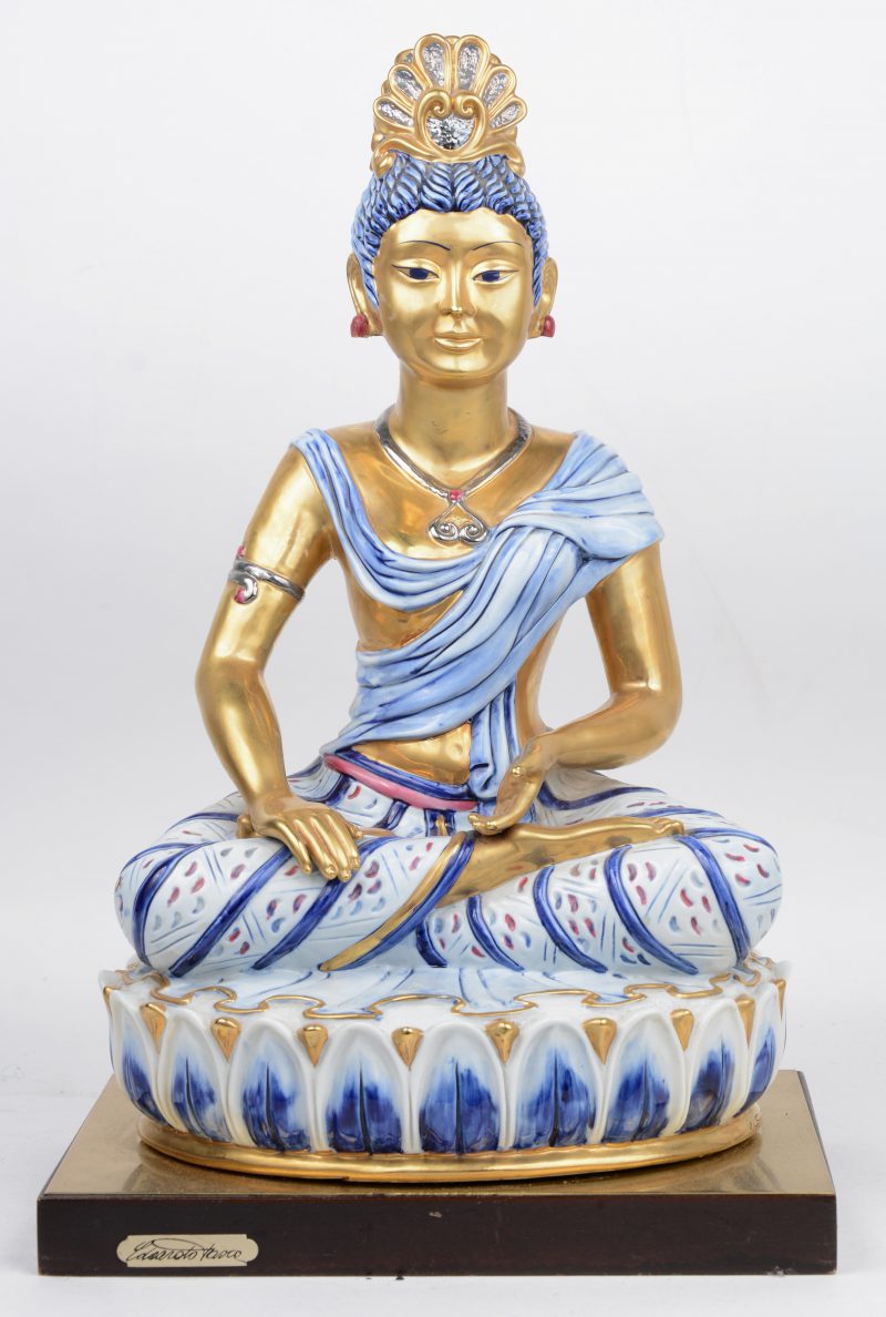 Een lampenvoet van meerkleurig en verguld Italiaans majolica in de vorm van een zittend figuur in Hindoeïstische stijl. Gemerkt en genummerd.