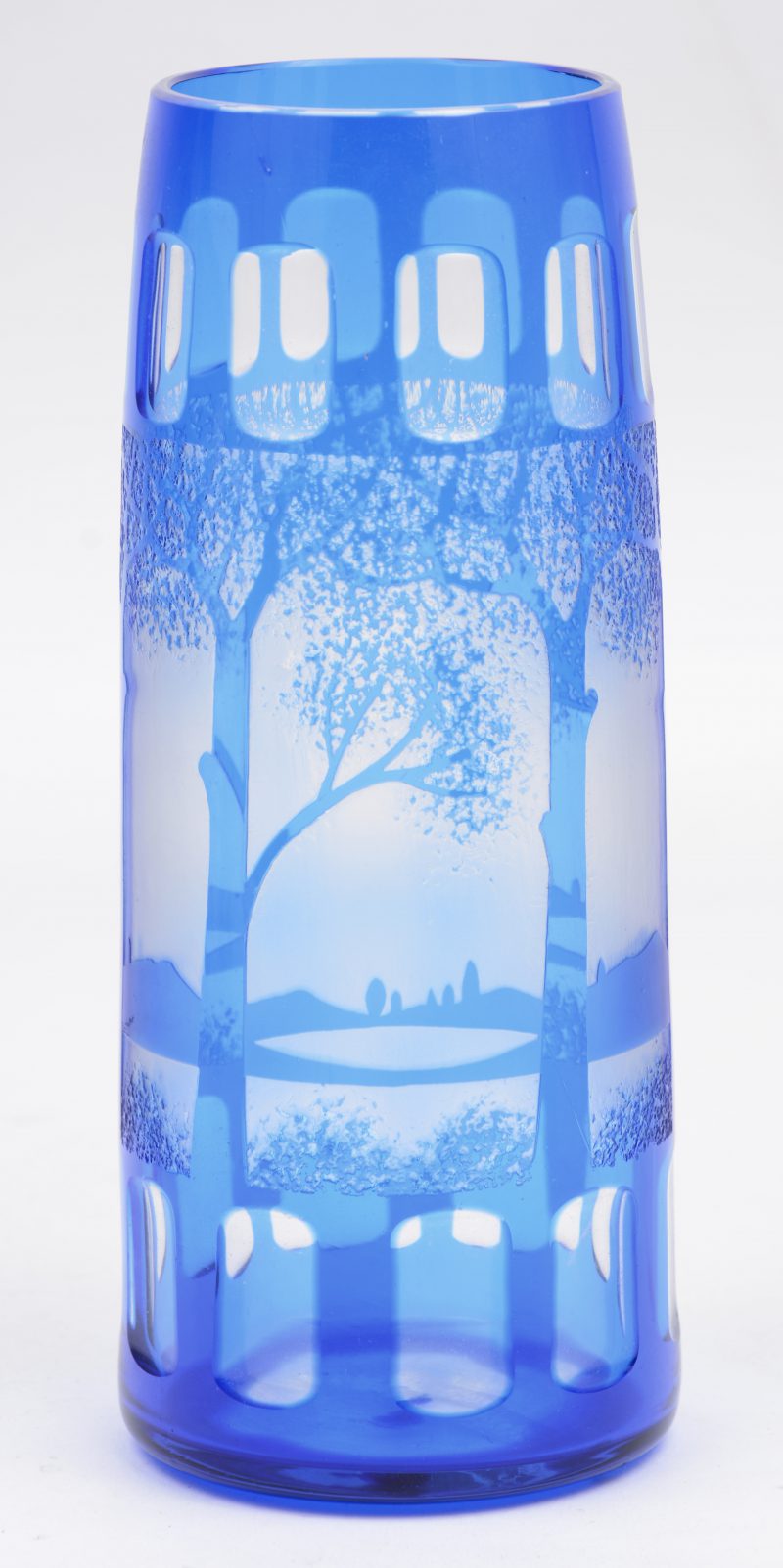 Een vaas van blauw glas met een geëtst en gesatineerd landschapsdecor.