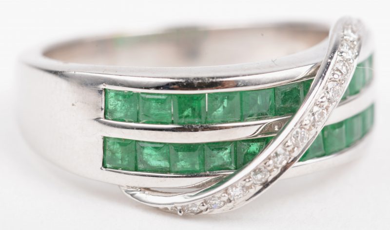 Een 18 K witgouden ring bezet met briljanten met een gezamenlijk gewicht van +- 0,12 ct. en smaragd cut met een gezamenlijk gewicht van 1,10 ct.