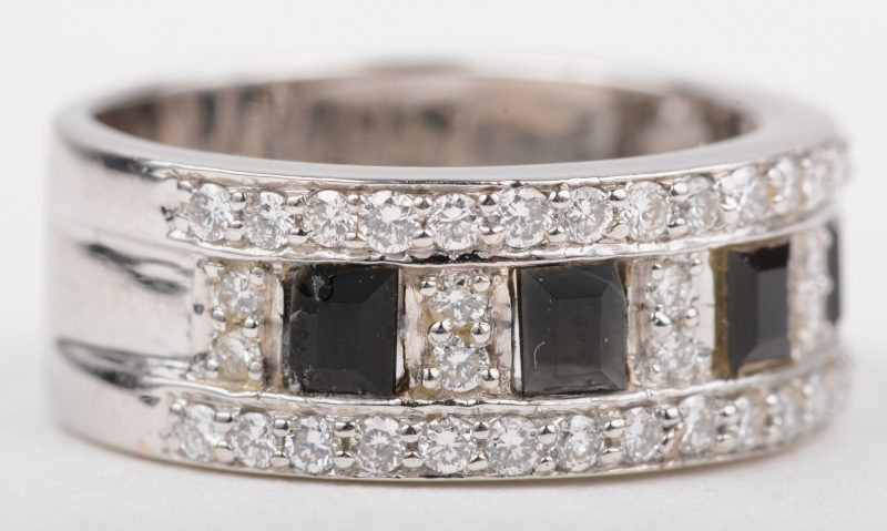 Een 18 K witgeelgouden ring bezet met een briljanten met een gezamenlijk gewicht van +- 0,92 ct. en onyx.