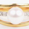 Een 18 K wit en geelgouden ring bezet met een briljanten met een gezamenlijk gewicht van +- 0,08 ct. en een parel.