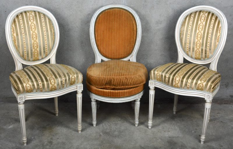 Twee witgepatineerde stoelen in Lodewijk XVI-stijl. Bijgevoegd een laag boudoirstoeltje in dezelfde stijl.
