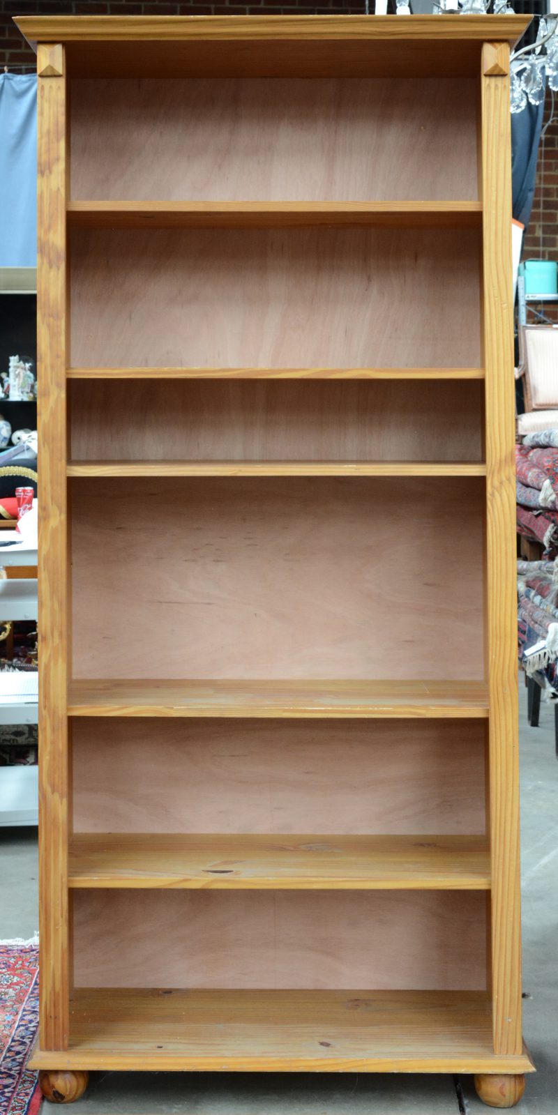 Een sobere grenenhouten boekenkast met vijf legplanken.