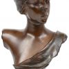 Een bronzen vrouwenbuste, verwerkt op een messingen lampvoet.