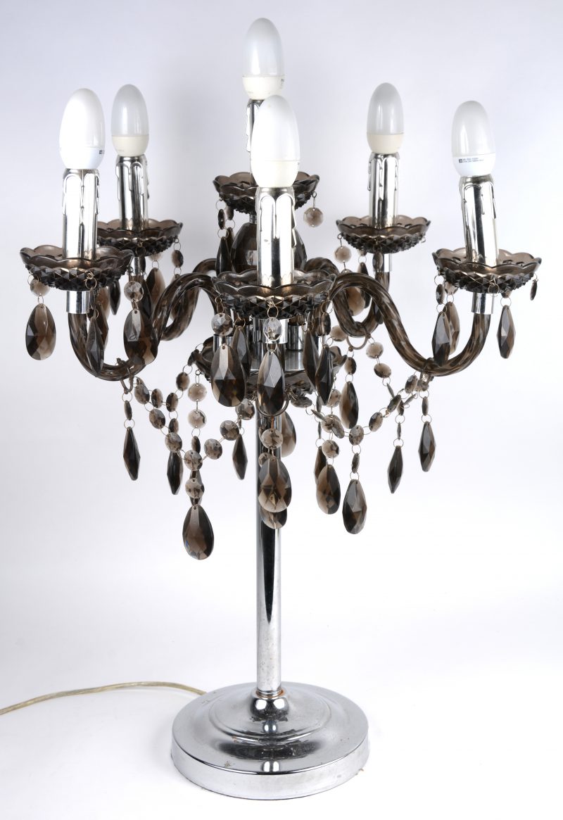 Een vijfarmige tafellamp met verchroomde voet en de lichtpunten versierd met geslepen rookbruin kristallen pendeloques.