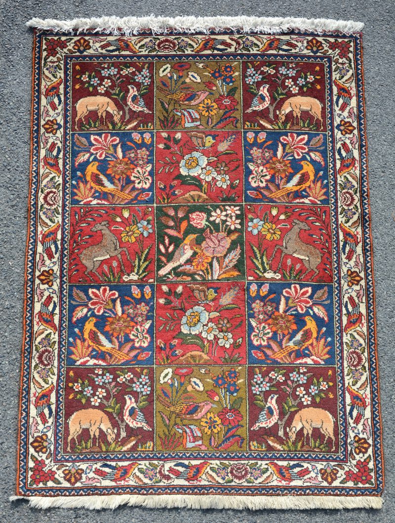 Een Oosters karpet met een tuinmotief met dieren.
