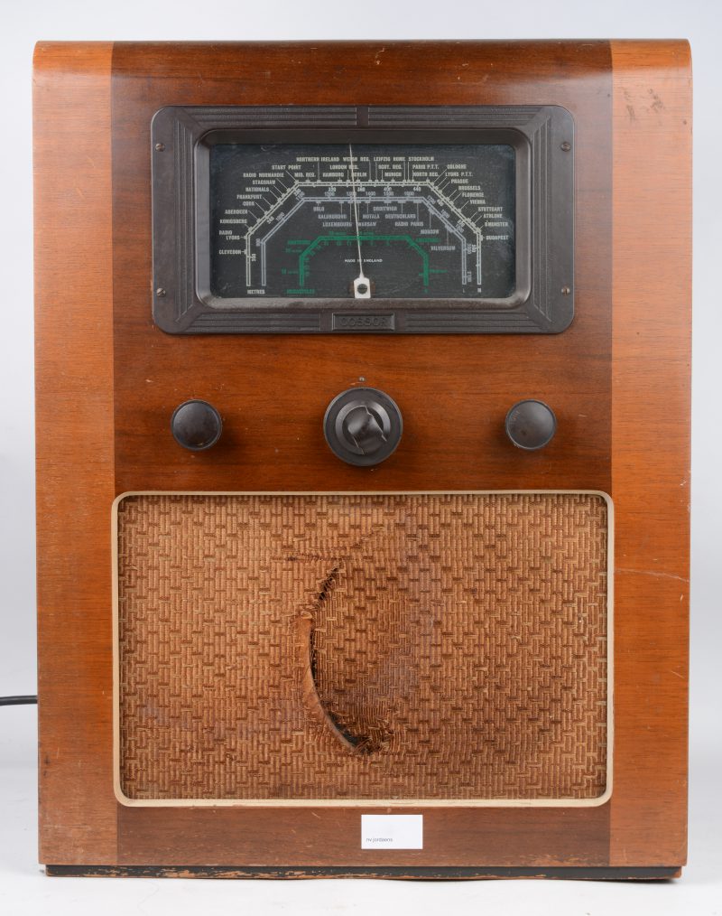 Een oude radio in houten kast. Luidsprekerdoek beschadigd.
