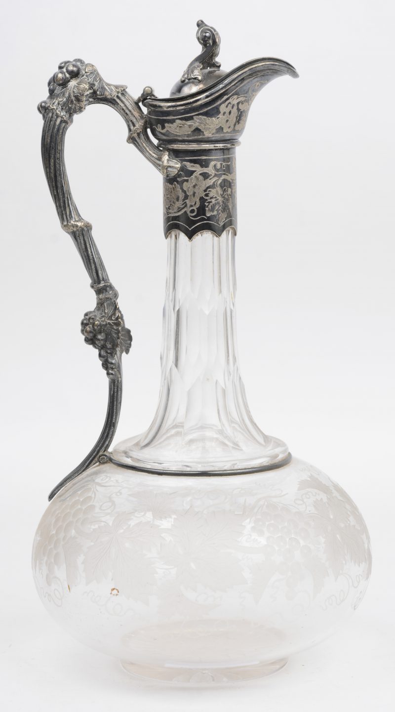 Een kristallen karaf met geslepen druivendecor en met verzilverde tuit en handvat. Gemerkt Thomas Prime & Son, “magneto-plated”. Engeland, XIXde eeuw.
